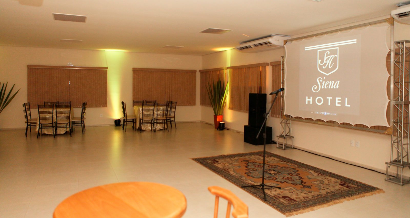 Salão de eventos do Siena Hotel com telão e som